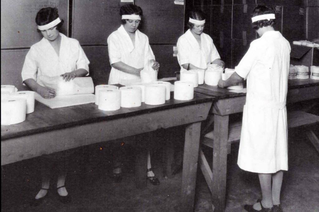 黑白照片，女工在工厂里包装卫生纸