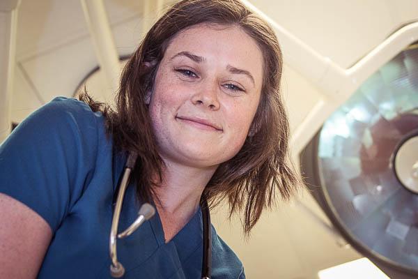 照片中，护士学生乔西·克拉科夫斯基在病床上抬头看着她