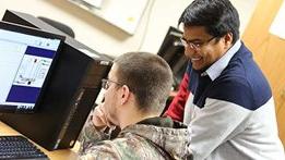 UW-绿湾's Md Maruf Hossain assisting an engineering tech student at a computer.